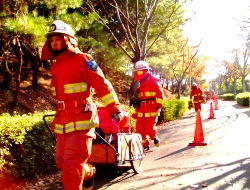 中継送水を行うために可搬ポンプを搬送する職員と消防団員